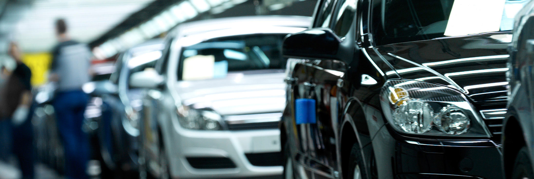 Mehrere Autos hintereinander auf dem Transportband eines Autoherstellers