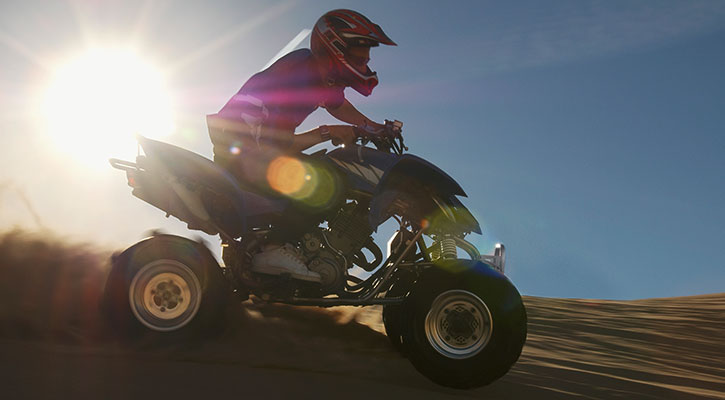 Hombre en un quad que se divierte haciendo drifting en carretera